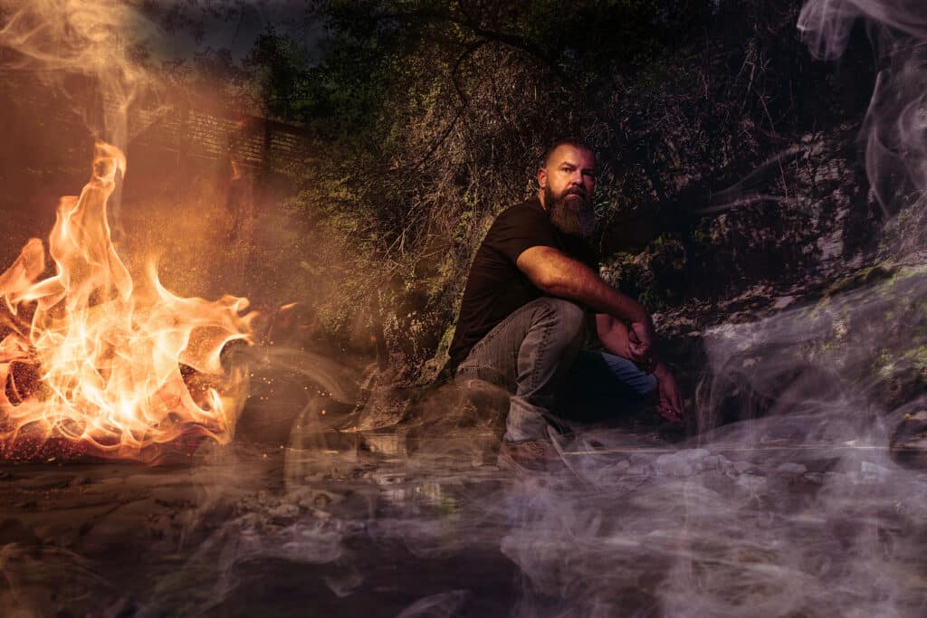 Man by campfire at night.