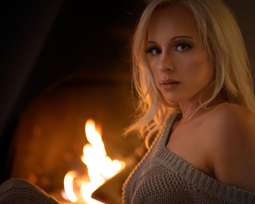 Pretty girl in front of a fireplace.