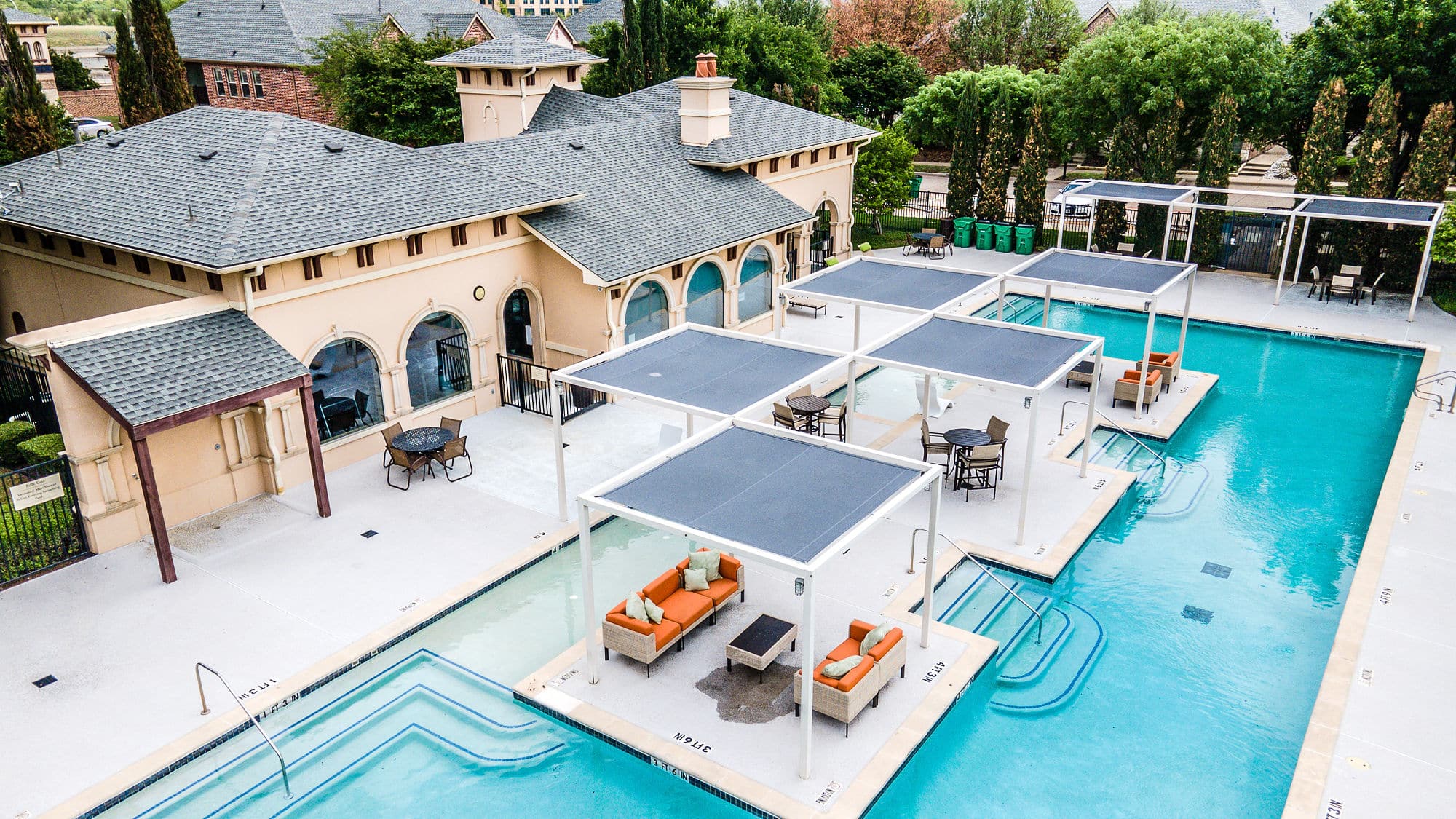 Birds Eye view of pool behind a large house.