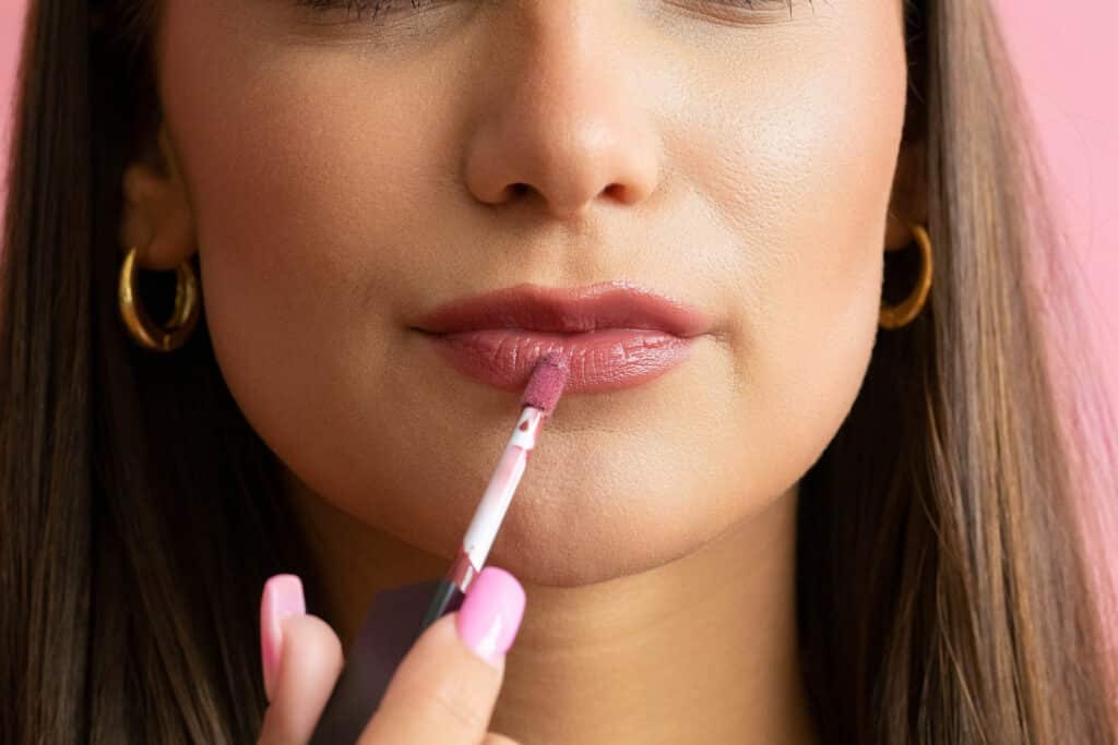 Woman allying lip gloss