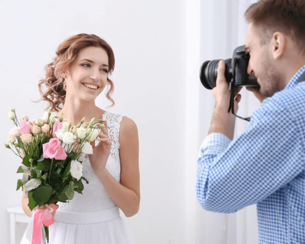 Photographer taking picture of girl with flowers.