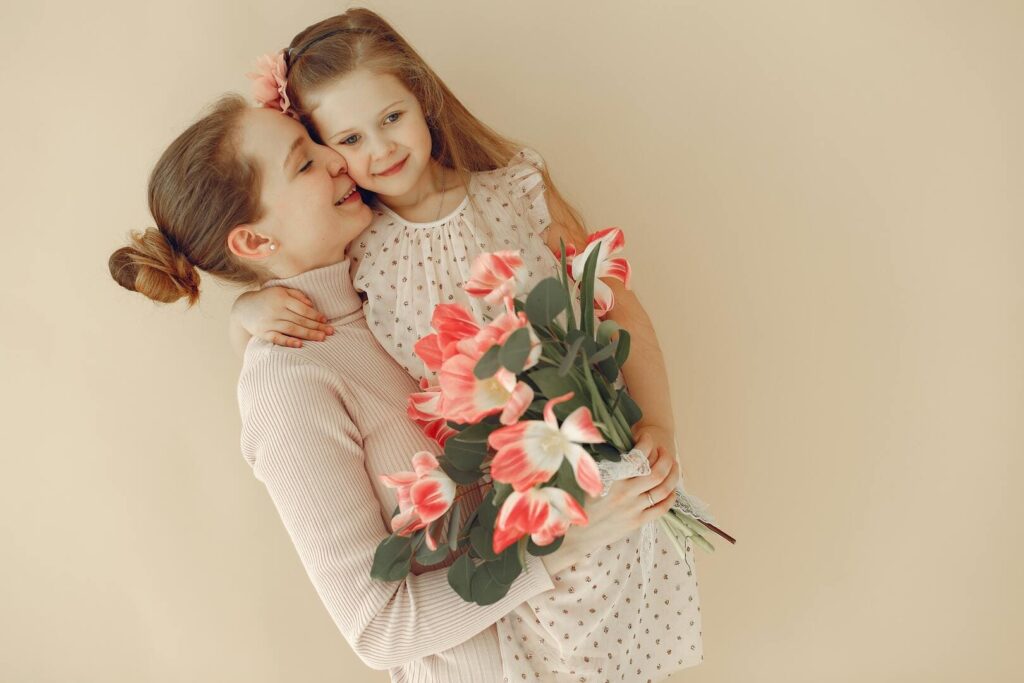 Mom and daughter holding flowers and posing.